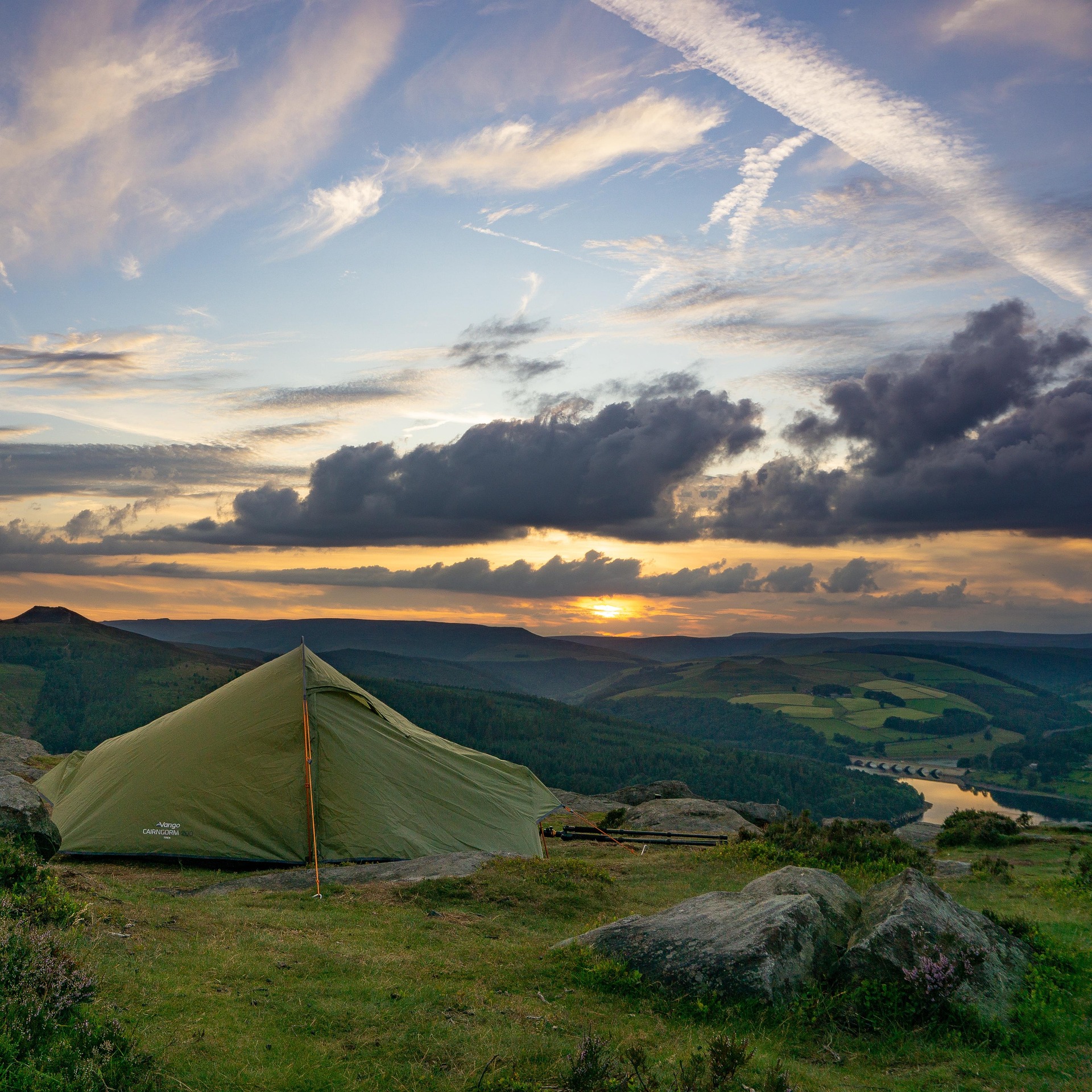 Zelt auf einem Hügel beim Sonnenuntergang – Mikroabenteuer in der Natur mit Blick ins Tal